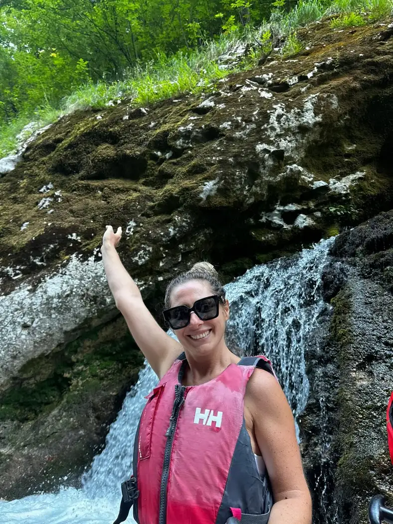 A colleague raising her arm in front of the rock face