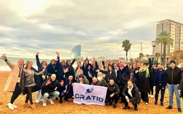 Das Oratio-Team mit Fahne am Strand von Barcelona