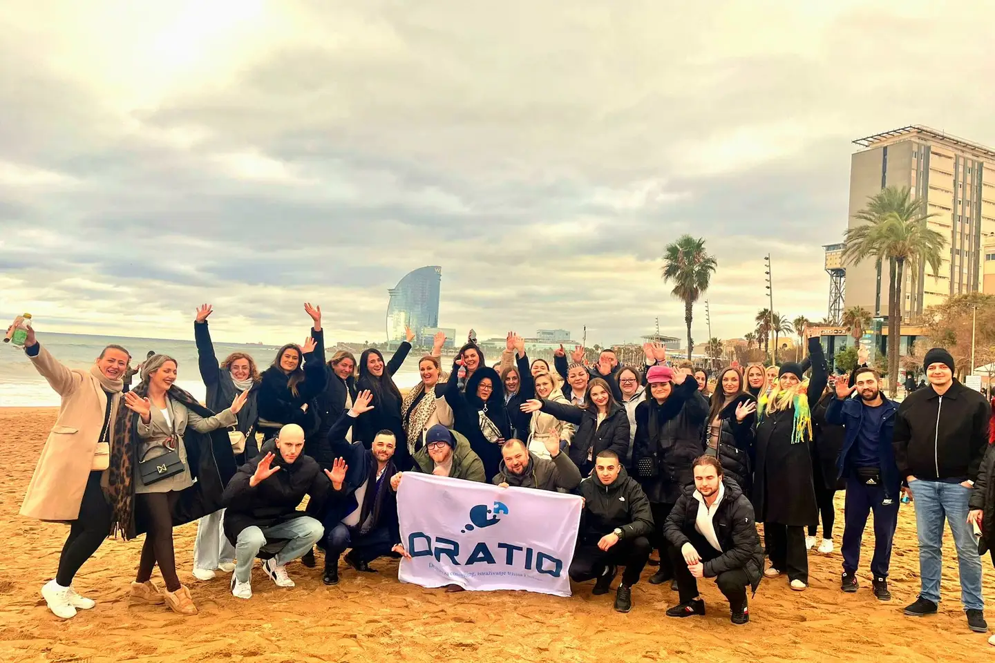 The Oratio team with its flag on the beach in Barcelona